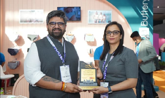 People browsing clothing at exhibition booth